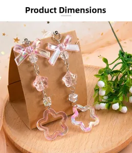 Detail of pink iridescent bow and hollow flower charms on a beaded dangle earring