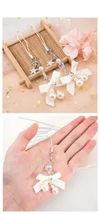 Détail d'un joli pendentif perle avec nœud et étoile pour téléphone ou appareil