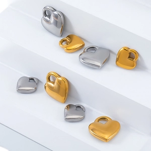 Polished gold and silver heart-shaped stainless steel pendants shown on a white display