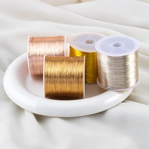 Four rolls of colorful jewelry copper wire for DIY craft on white silk background