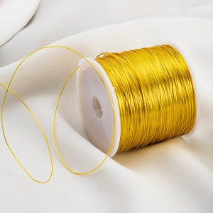 Golden craft wire on white spool for DIY jewelry making and delicate wire weaving