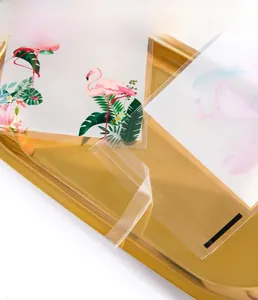 Detail of clear self-adhesive gift bag with flamingo illustration card on golden tray