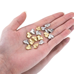 Exquisite zircon heart charms in gold and silver held by hand for jewelry making