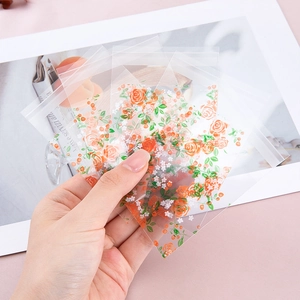 Clear self-adhesive plastic bags with orange floral prints for cookies and candy