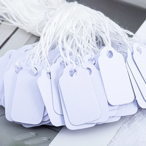 Set van witte rechthoekige papieren labels met katoenen koord voor cadeauverpakkingen