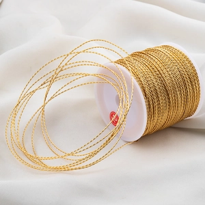 Metallic gold twisted embroidery thread on white spool for DIY jewelry making and crafts