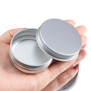 Hand holding a 40ml silver round aluminum tin container with screw lid for cosmetics