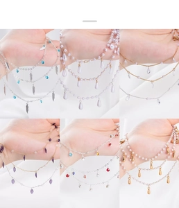 Detail of bohemian style charms with silver leaves, pearls, and colorful crystals