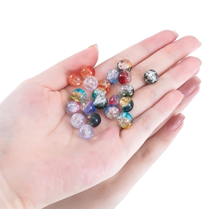 Hand holding colorful 10mm crackle glass beads for DIY jewelry making and bracelets