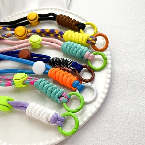 Adjustable woven paracord crossbody phone strap with round spring rings in various colors
