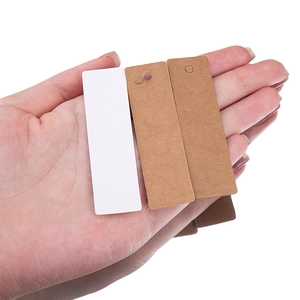 Handheld view of brown and white blank kraft paper tags with pre-punched hanging holes
