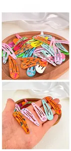 Detail of colorful printed metal BB hair clips with floral and animal patterns in a tray