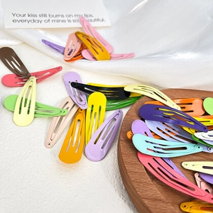 Colorful drop-shaped metal BB hair clips in various macaron colors on a white surface
