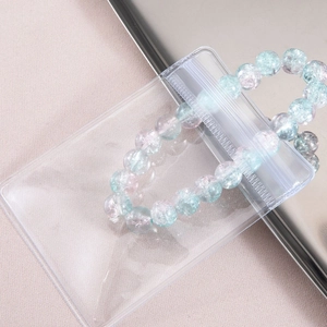 Bracelet en perles bleu et rose effet craquelé dans une pochette transparente en PVC