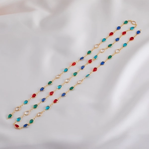 Detailed view of teardrop colorful crystal faceted charms on a gold chain necklace