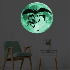 Luminous Halloween moon wall sticker with bats glowing green in a dark room setting