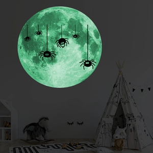Sticker mural pleine lune phosphorescent avec araignée brillant dans une chambre d'enfant