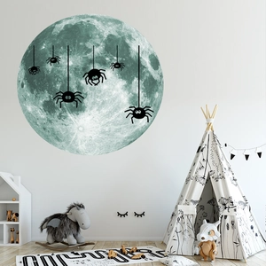 Détail des stickers muraux lune lumineuse et araignées dans une chambre d'enfant moderne