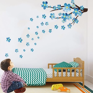Blue plum blossom wall decal showing brown branches and falling flowers in a kids room