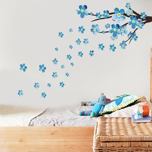 Detail of blue plum blossom wall sticker on a bedroom wall with cozy home decor