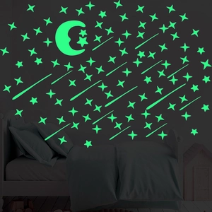 Luminous wall stickers set showing glowing green moon and stars in a dark bedroom setting