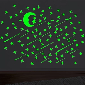 Glow in the dark wall stickers showing luminous green moon and stars in a night room