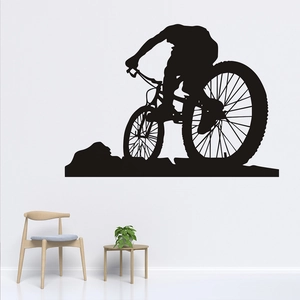 Détail d'un sticker mural de silhouette de VTT noir sur un mur blanc dans un salon moderne