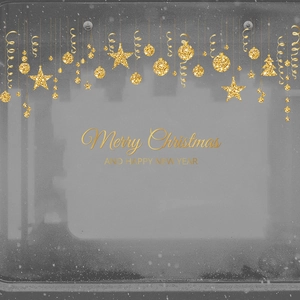 Close-up of golden glitter Christmas ornaments with Merry Christmas lettering on dark background
