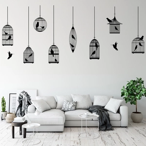 Minimalist black birdcage wall decals showing flying birds silhouette over a living room sofa