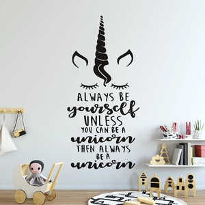Détail d'un sticker mural licorne avec citation dans une chambre d'enfant épurée