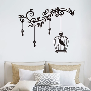 Black silhouette wall sticker featuring vintage birdcage and keys on a bedroom wall
