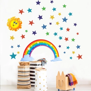 Cartoon rainbow, sun and colorful stars wall decals in a bright, modern nursery room