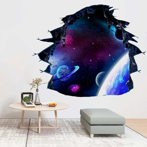 3D space wall decal showing a blue galaxy planet breaking through a white wall in a bedroom
