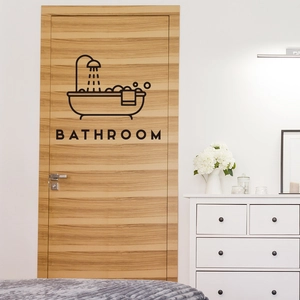 Detail of black waterproof bathroom wall sticker with bathtub icon on a wooden door
