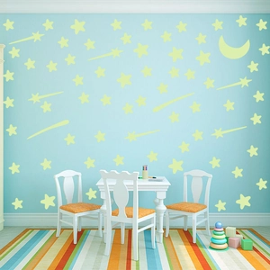 Luminous star and moon wall sticker set displayed in a cozy blue kids bedroom setting