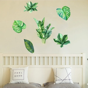 Detail of watercolor tropical monstera and palm leaf wall stickers in a bedroom