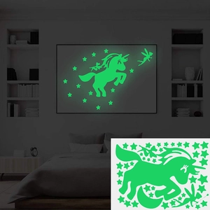 Luminous wall stickers set featuring unicorns and stars glowing in a dark bedroom