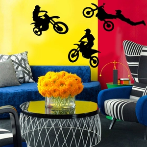 Detailed view of three black motocross silhouette wall stickers on a modern living room wall
