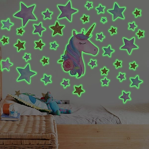 Detailed view of luminous unicorn and stars wall stickers glowing in a kids bedroom