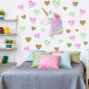 Detailed view of unicorn wall stickers with gold hearts on a bedroom wall setup