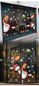 Détail de stickers de Noël avec Père Noël et flocons de neige sur une vitrine en verre