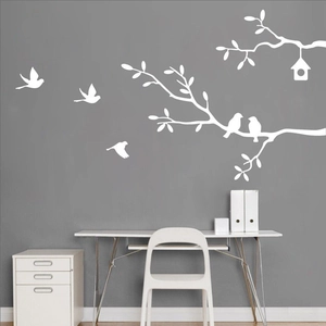 Detail of white tree branch and bird wall decals on a minimalist dark grey wall