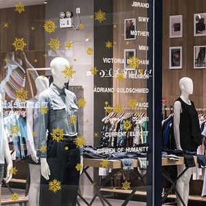 Christmas window decals with gold silk-screened snowflakes for festive shop displays