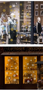Detail of gold and silver snowflake window decals on glass storefront for Christmas