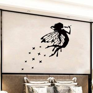 Detail of black fairy silhouette wall sticker with stars above a modern bedroom bed
