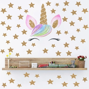 Détail de sticker mural licorne dorée avec crinière aquarelle et étoiles dans une chambre