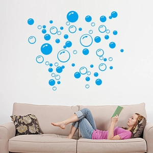 Blue bubble wall decals displayed in a cozy living room setting above a modern beige sofa