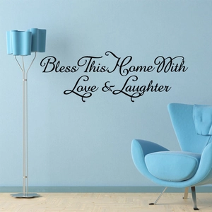 Detail of Bless This Home wall decal in black script on a blue living room wall