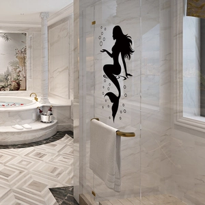 Detail of waterproof black mermaid silhouette wall decal on a luxury marble bathroom glass