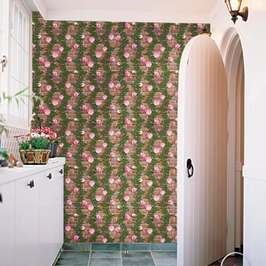 Detail of self-adhesive red brick wallpaper with pink climbing roses in a white hallway